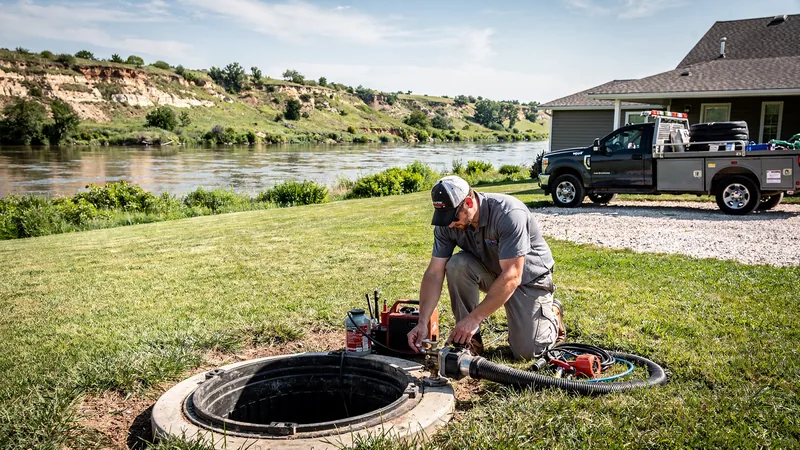 Septic service technician working on a residential septic tank in Tecumseh, KS